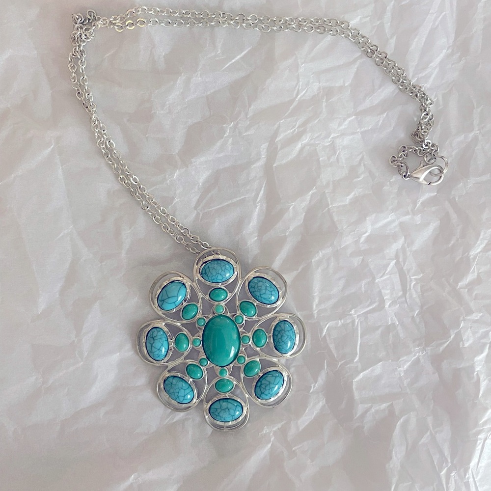 Stunning teal colored chain with teal blue stone pendant. Gorgeous accent piece!